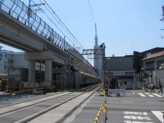 京成曳舟駅前にある京成曳舟1号踏切〈明治通り〉から押上方を見る。中央には東京スカイツリー。