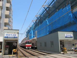同じ踏切から京成曳舟駅のホームと建設中の高架橋を見る。